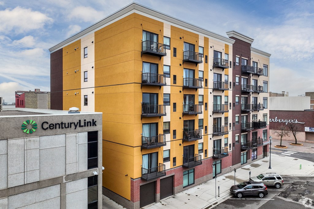 a yellow apartment building with a community link sign in front of it
