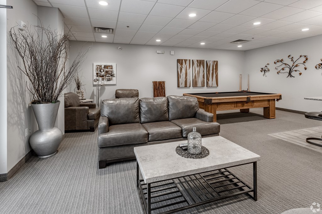 a living room with a pool table and couches