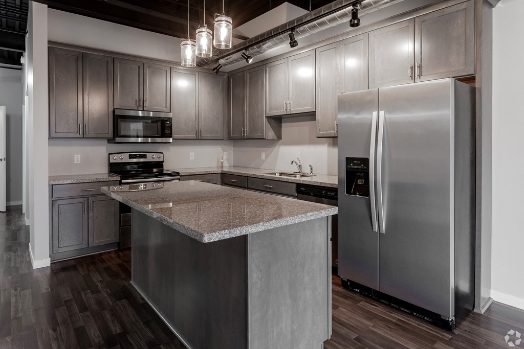 an updated kitchen with stainless steel appliances and granite counter tops