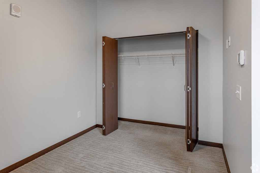 an empty room with a closet with a door open