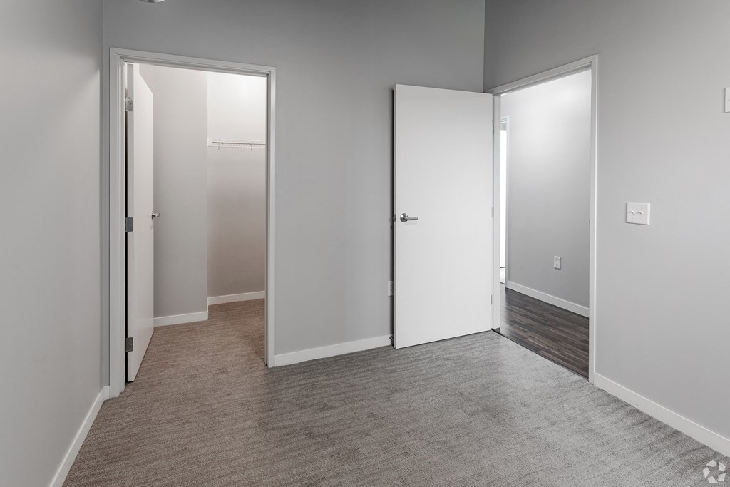 an empty room with white doors and a carpeted floor
