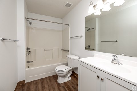 A white bathroom with a toilet, sink, and bathtub.