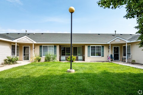 A grassy area in front of a building with a lamp post.