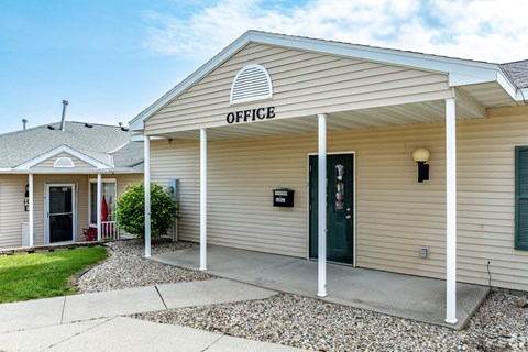 A small building with a porch and a sign that says "OFFICE".