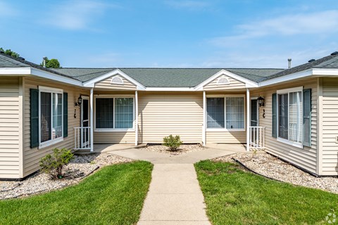 A row of houses with green lawns in front.