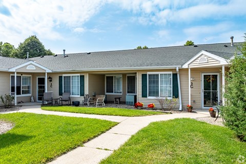 A house with a grey roof and a green lawn in front.