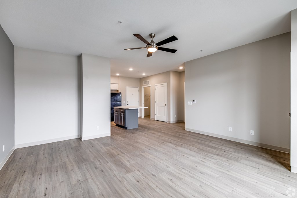 A room with a ceiling fan and wooden flooring.