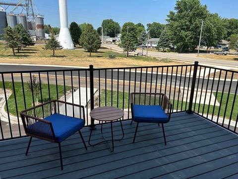a patio with two chairs and a table on a balcony