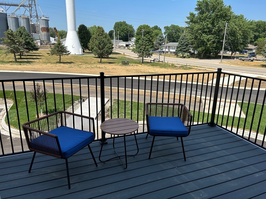 a patio with two chairs and a table on a balcony