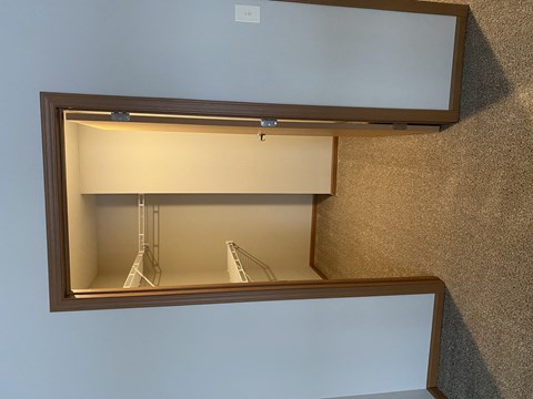 A mirror with a wooden frame is mounted on a wall.