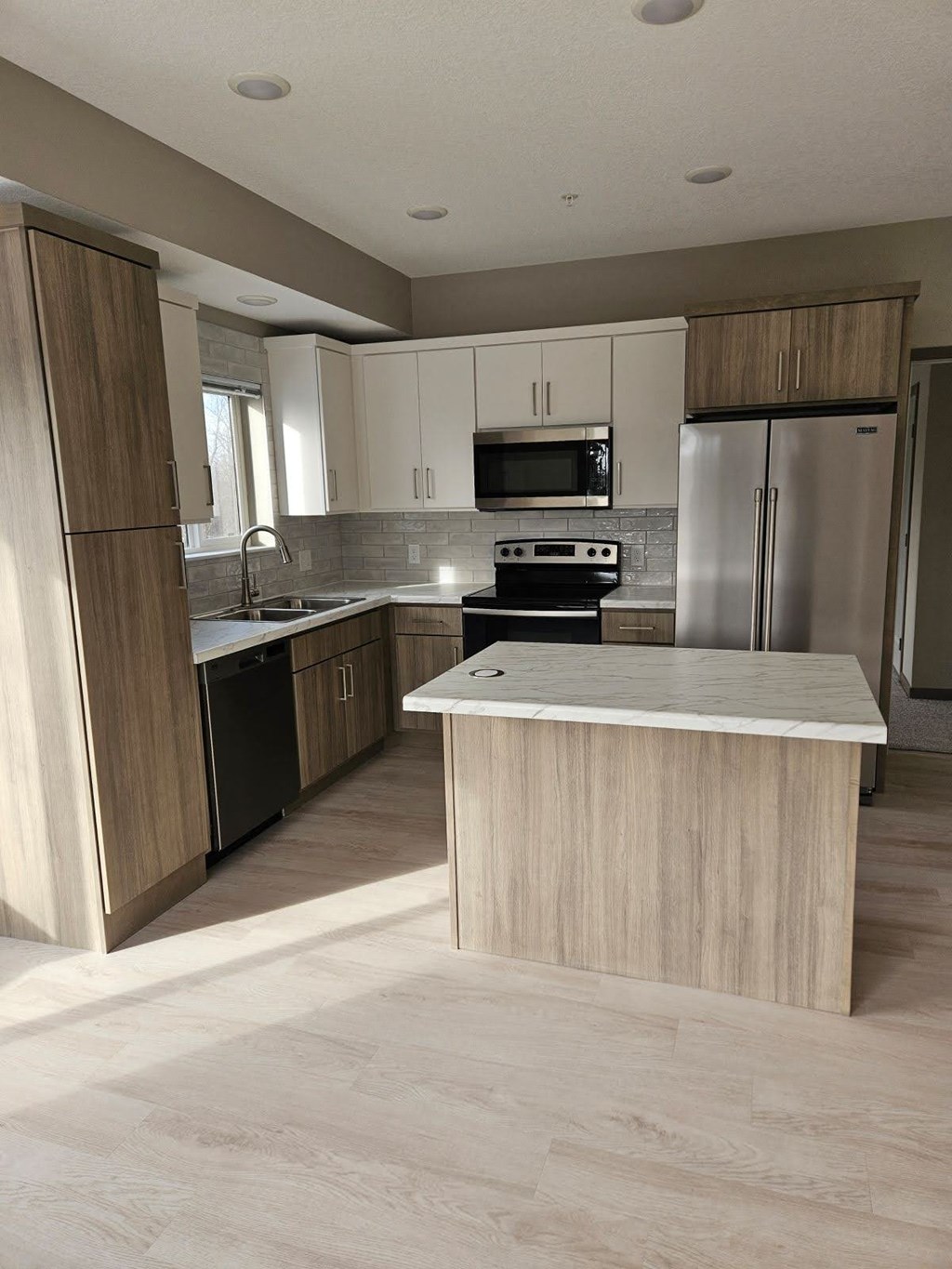 A kitchen with a white island in the middle of it.