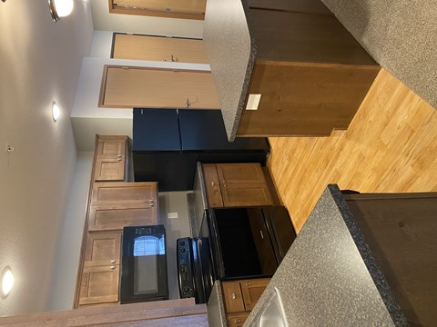 A kitchen with wooden cabinets and black appliances.