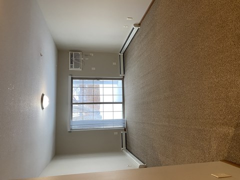 A room with a window and a wall on the left side.