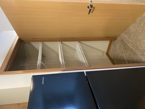 A wooden cabinet with a black door and a silver handle.