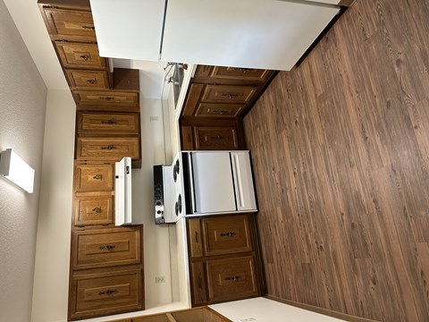 A kitchen with wooden cabinets and drawers.