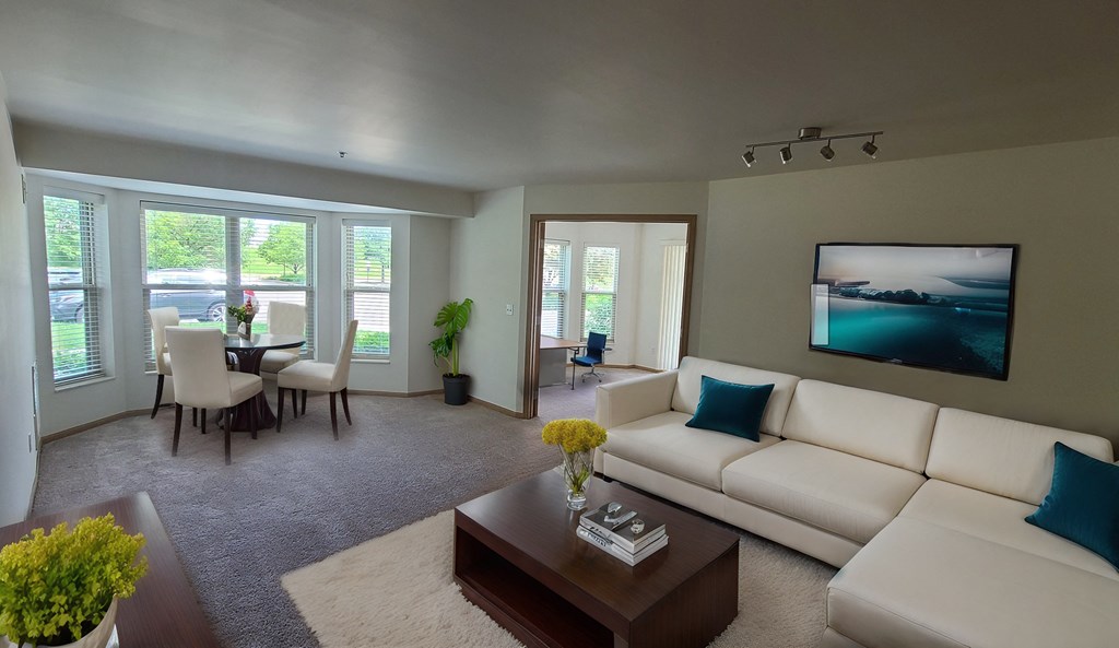 a living room and dining room with a white couch and a coffee table