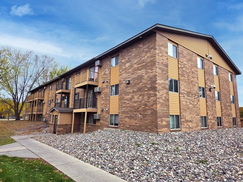 A large brick building with a grassy area in front.