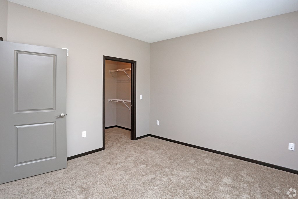 an empty room with a closet and a door to a bathroom