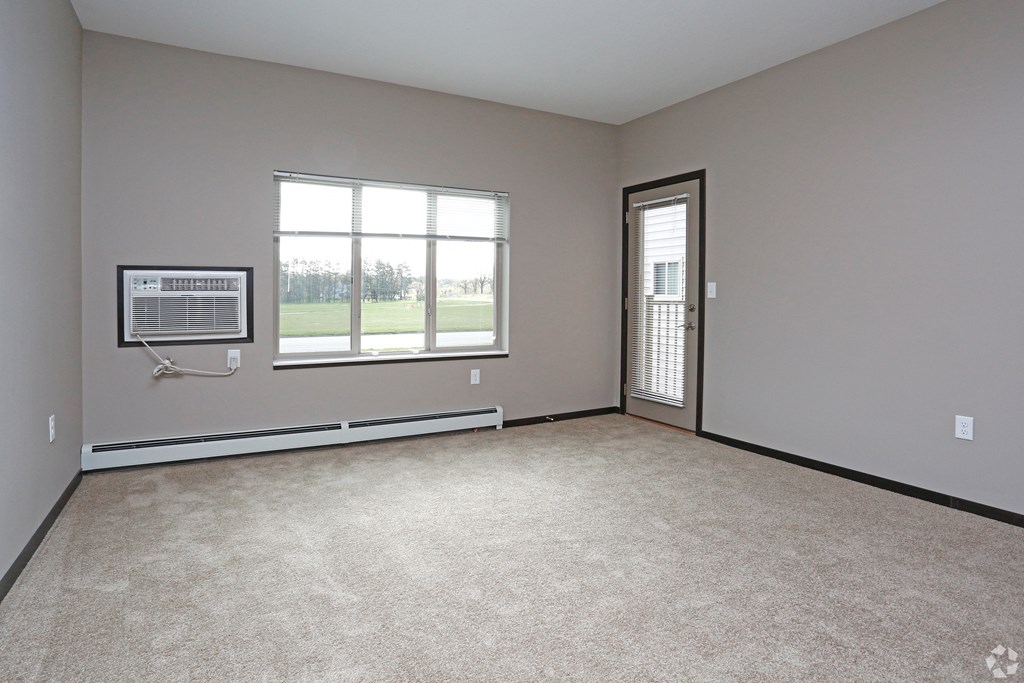 an empty living room with a window and a door