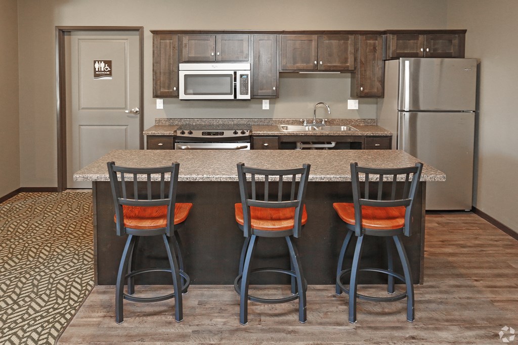 a kitchen with a large island with four chairs