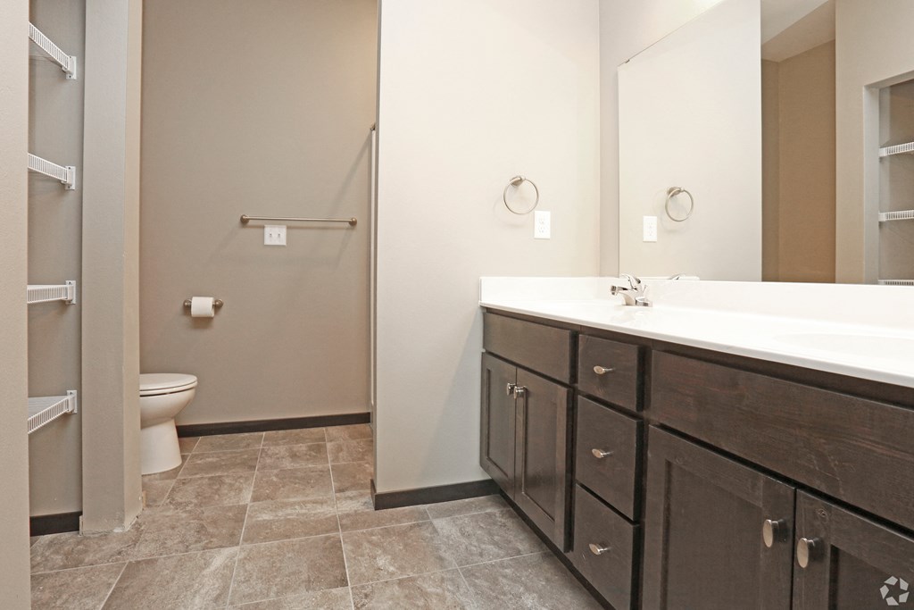 a bathroom with a large mirror and a sink and a toilet