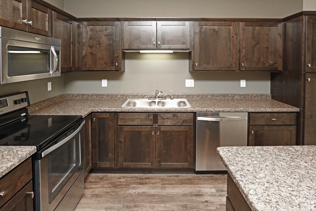 a kitchen with wooden cabinets and stainless steel appliances