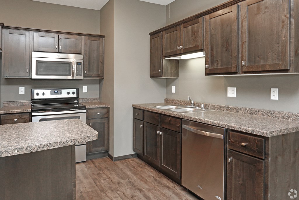 a kitchen with wooden cabinets and granite counter tops and stainless steel appliances