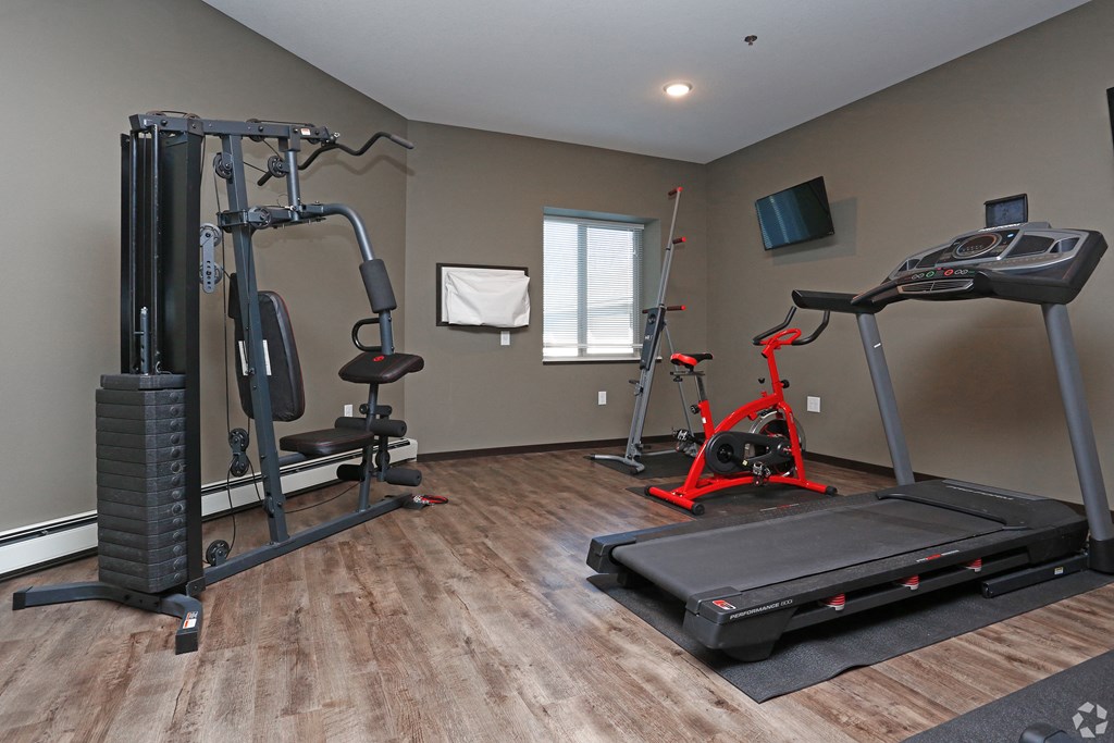 a gym with exercise equipment and a tv
