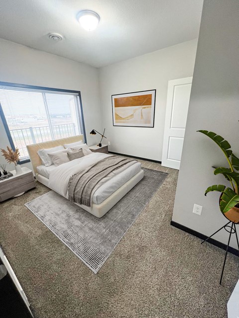 A bedroom with a large bed and a painting on the wall.