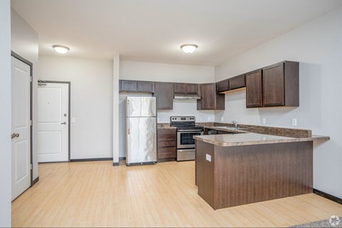 A kitchen with a wooden island and stainless steel appliances.