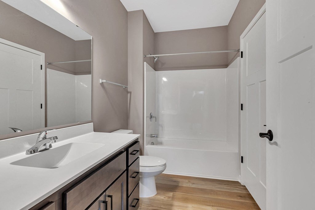 A bathroom with a white sink and a white toilet.