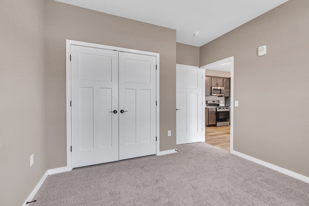 A room with a white door and a carpeted floor.