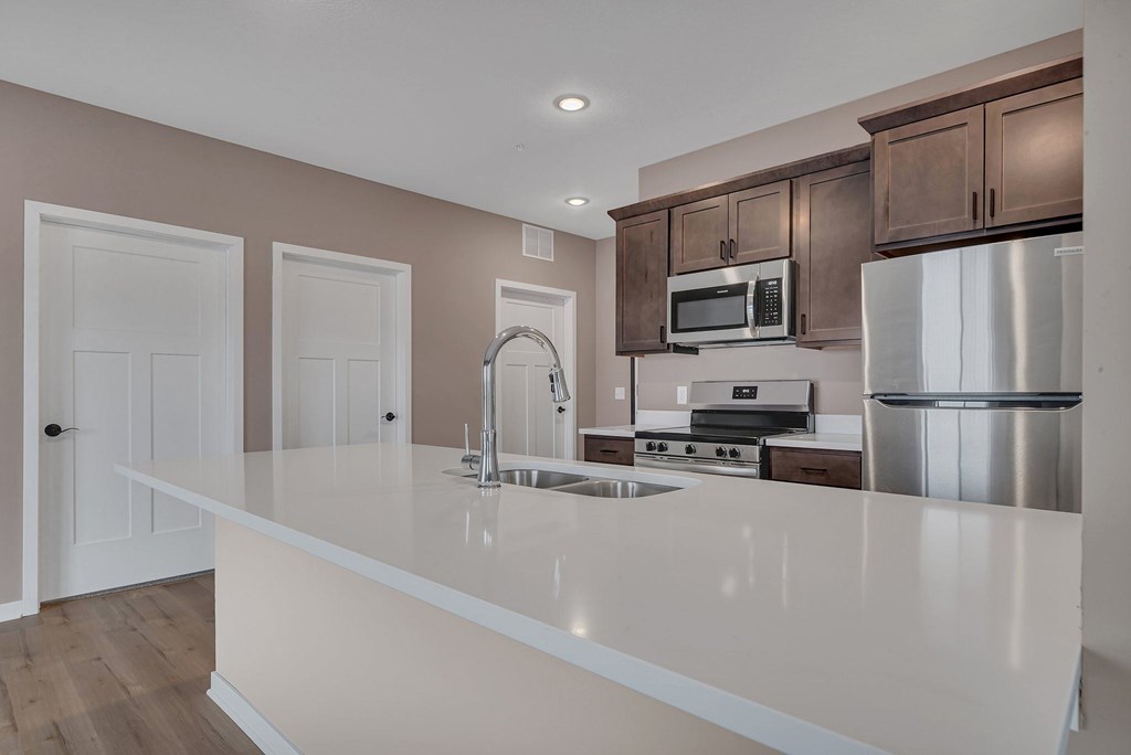 A kitchen with a white countertop and brown cabinets.