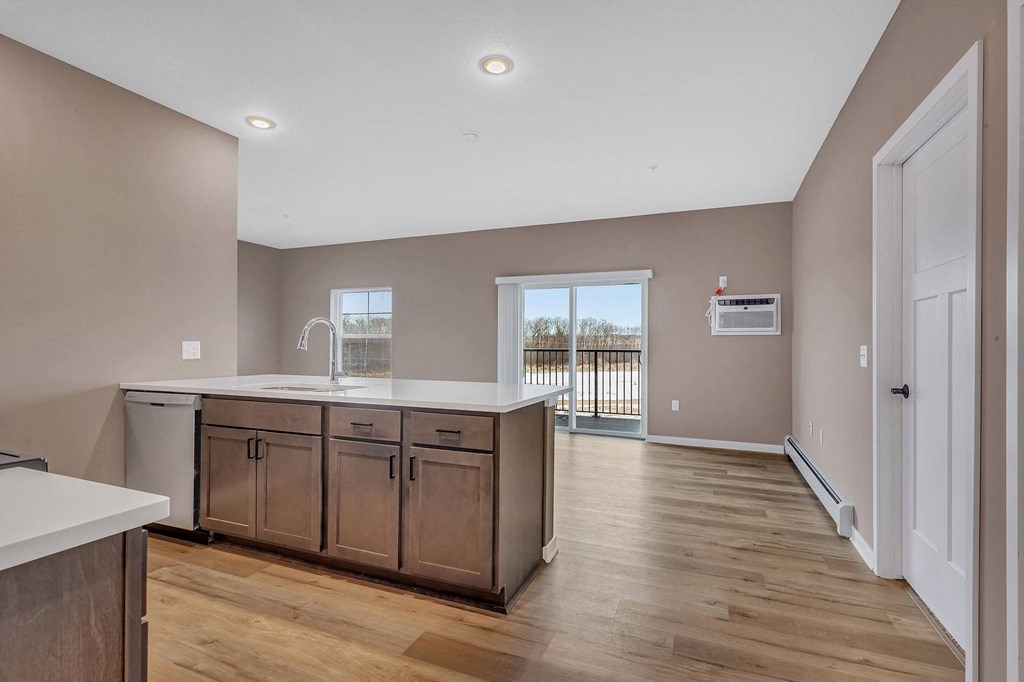 A kitchen with wooden floors and a white counter.