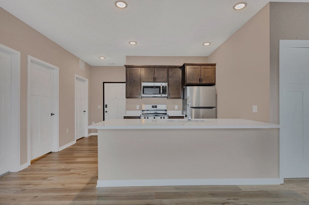 A kitchen with a white counter and brown cabinets.