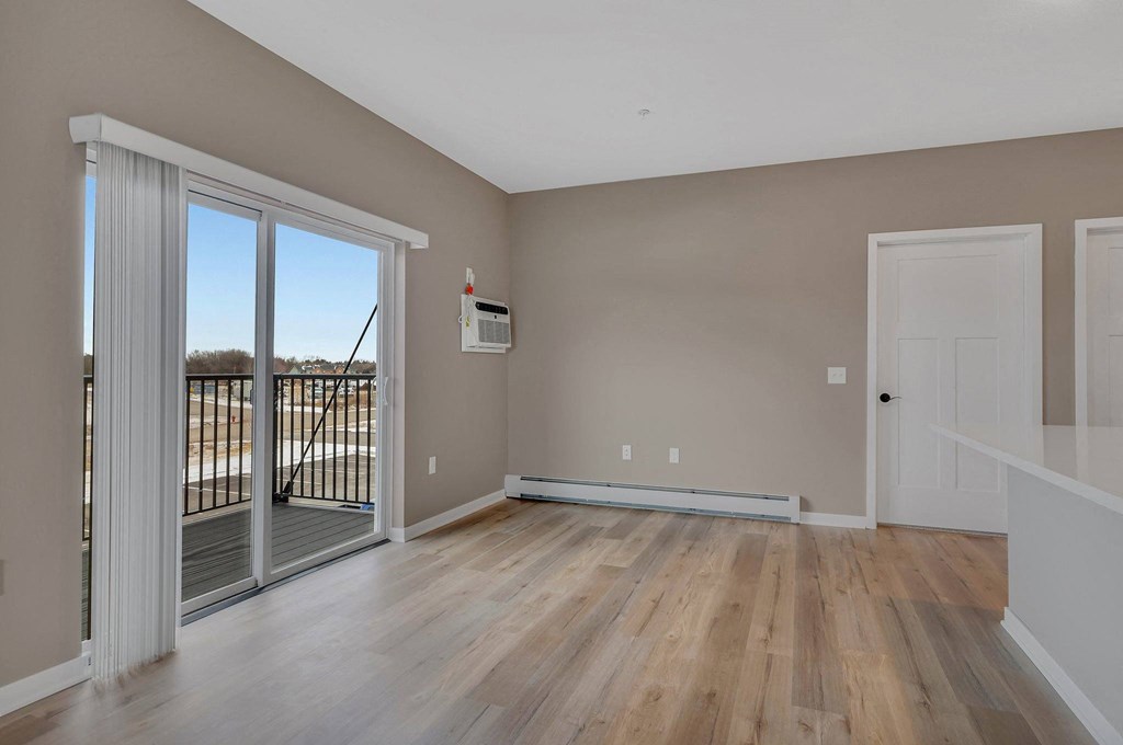 A room with a sliding glass door leading to a balcony.