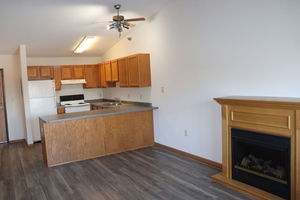 A kitchen with wooden cabinets and a fireplace.