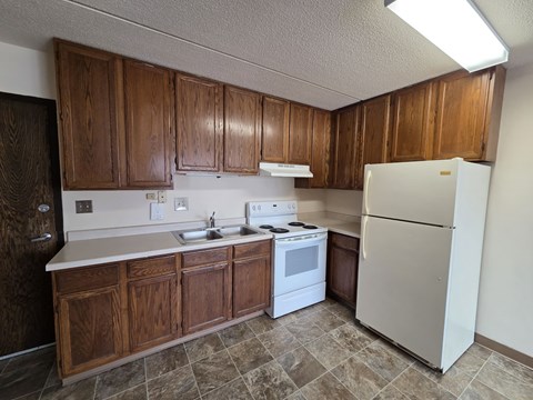 A kitchen with wooden cabinets and a white refrigerator.