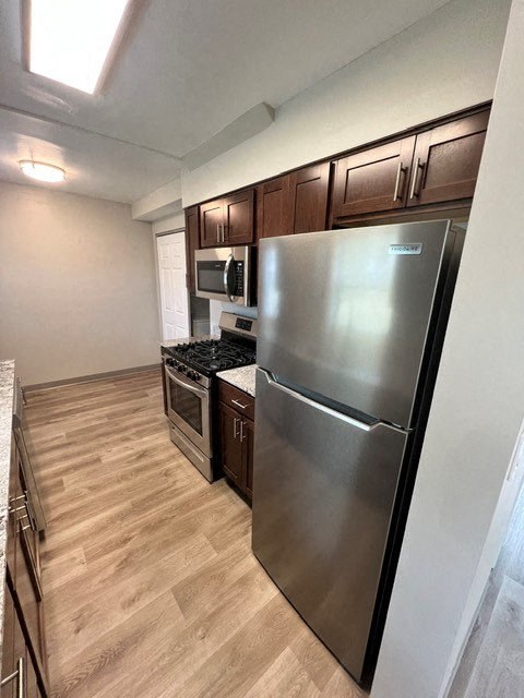 a kitchen with a stainless steel refrigerator