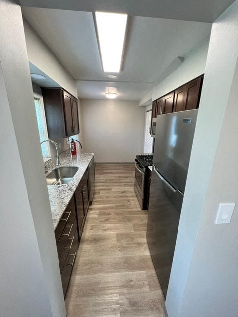 a kitchen with a stainless steel refrigerator and a sink