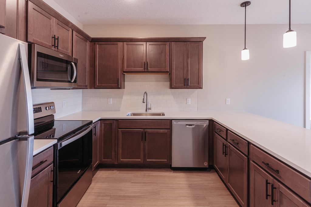 an empty kitchen with wooden cabinets and stainless steel appliances