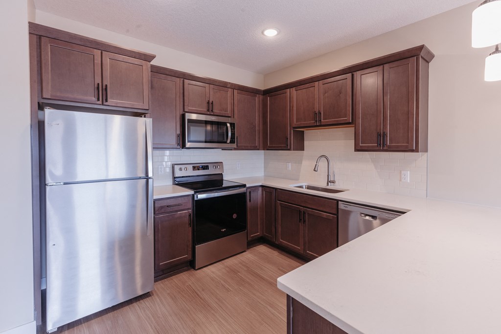 an empty kitchen with wooden cabinets and stainless steel appliances