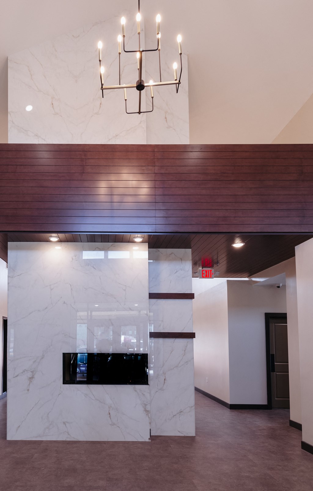 a marble wall with a fireplace and a chandelier