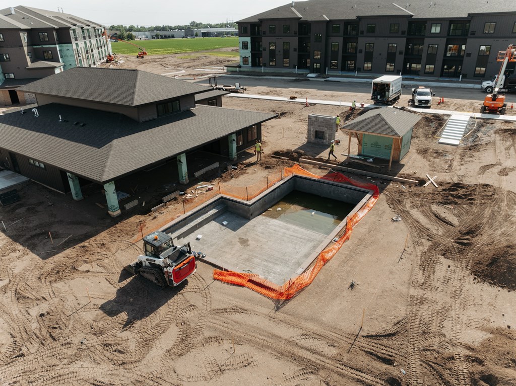 a construction site with a building and a pool in the dirt