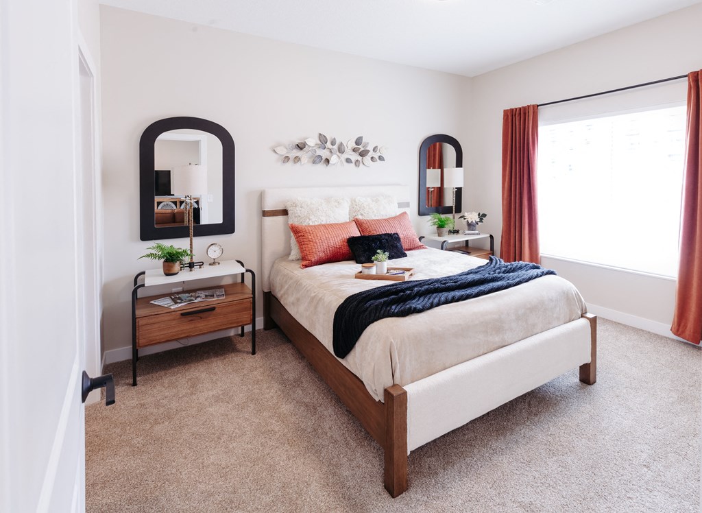 a bedroom with a bed and a mirror on the wall