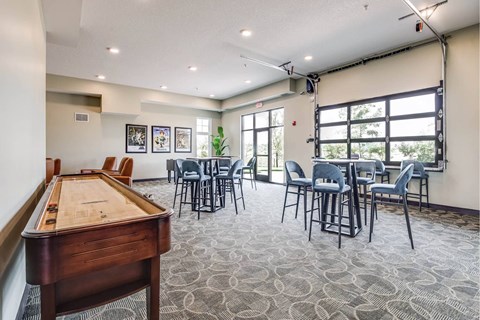 A room with a pool table and chairs.