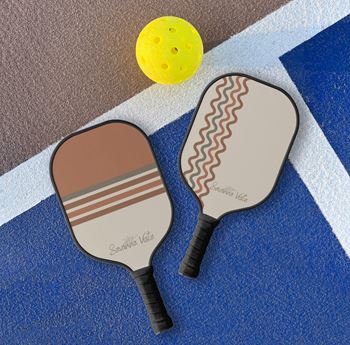 two tennis rackets on the floor next to a tennis ball