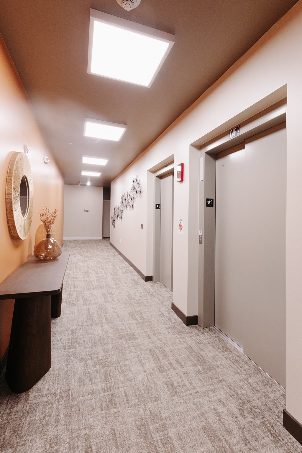 a hallway with white walls and white doors and a table with a vase