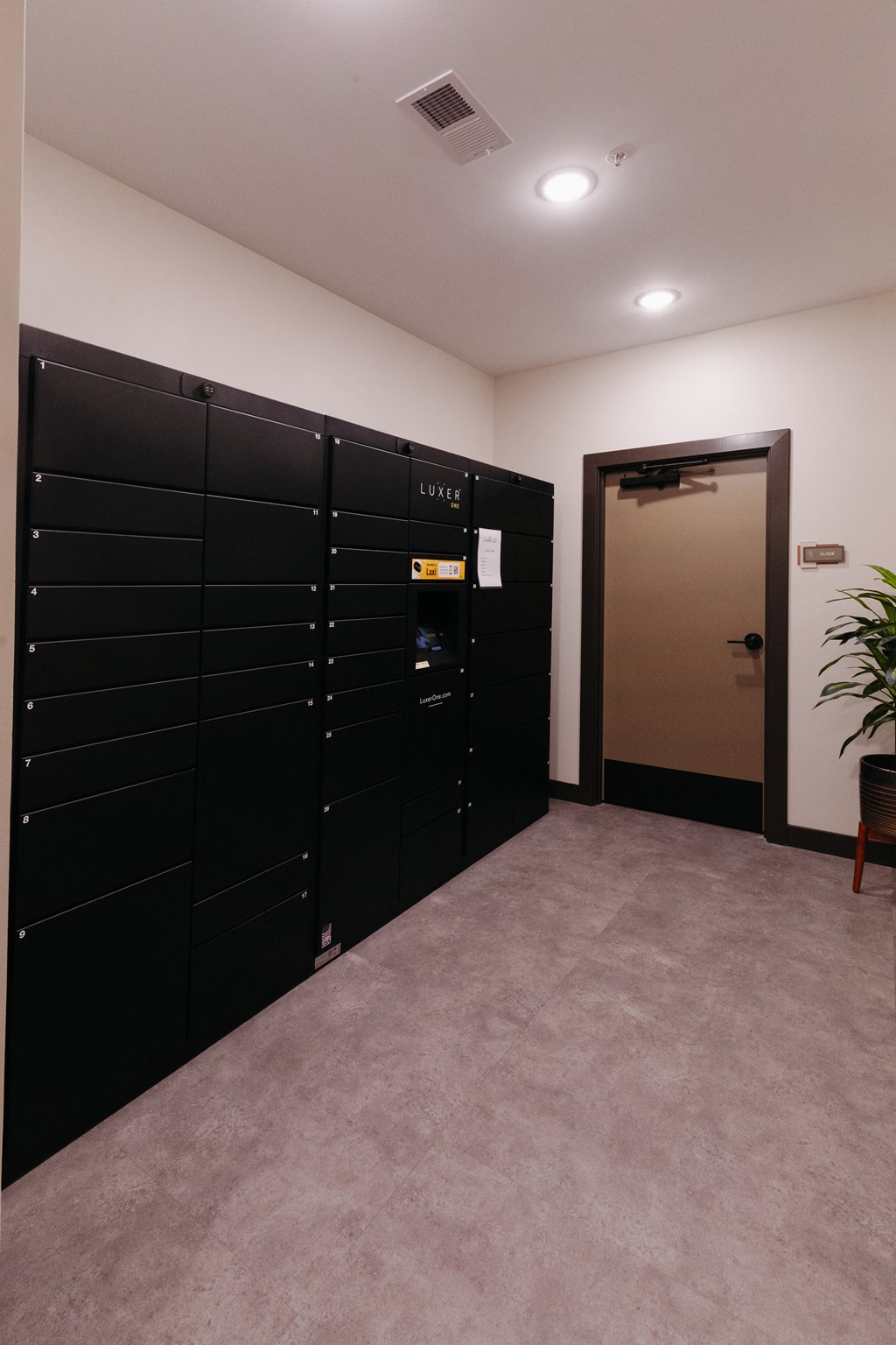 a row of black lockers in a room with an open door