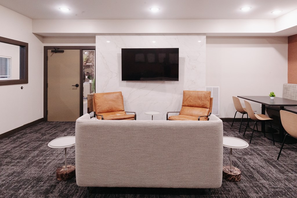 a living room with a couch and chairs and a television